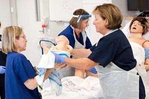 Midwives training with a dummy patient and baby