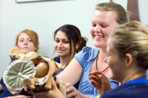 A training baby dummy being passed to students