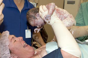 Mum holding up new born baby