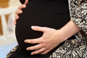 Hands holding pregnant belly